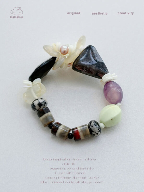 Close-up of the carved shell flower and freshwater pearl on Night Garden bracelet